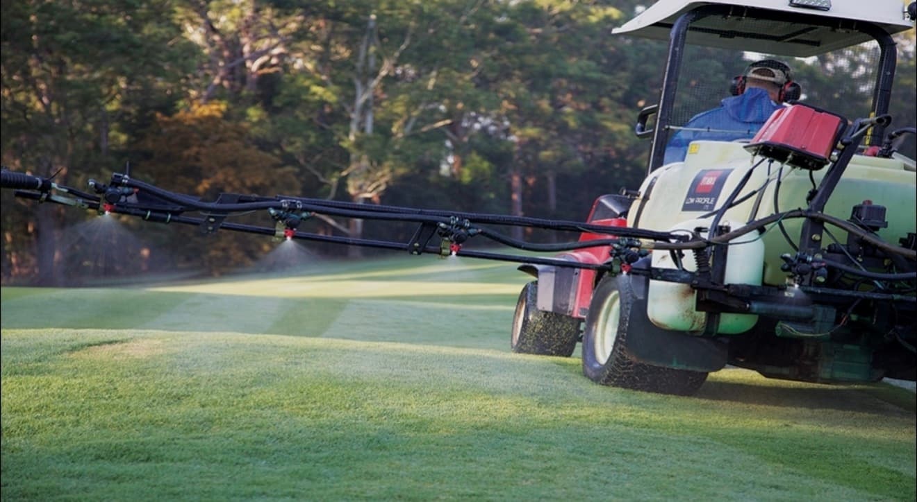 Turf maintenance equipment working across a commercial sports grounds site