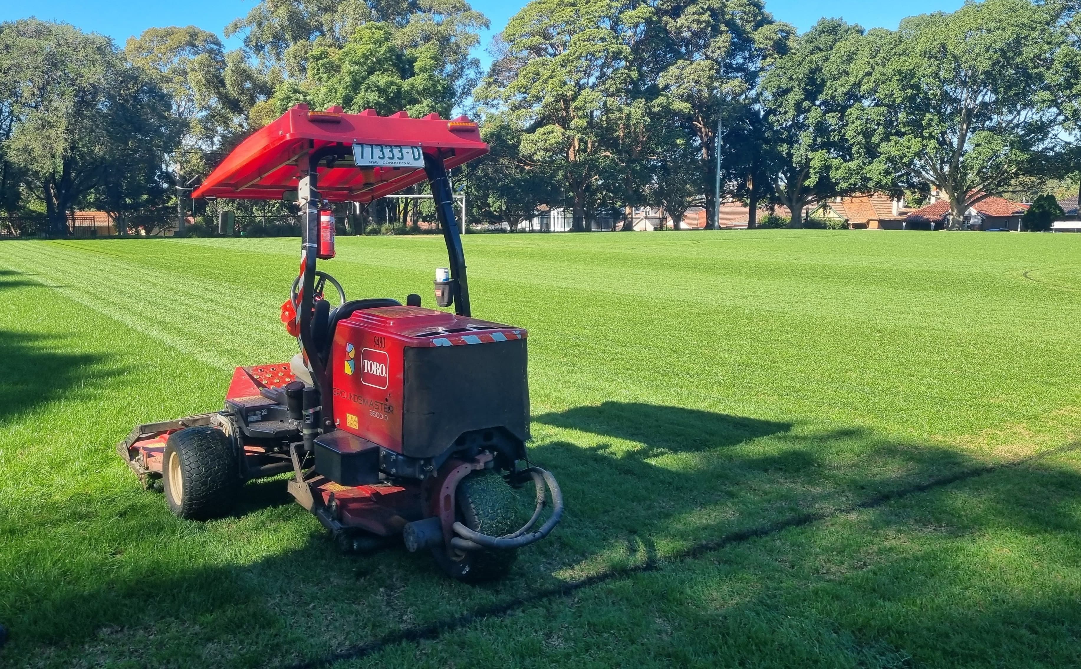 Cylinder mower cutting striped turf on a sports field